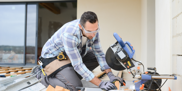 Professional contractor cutting wood with a miter saw during a deck installation project